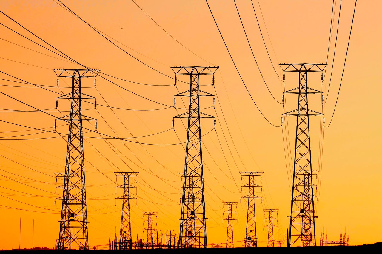 Mastering the First Impression: Your intriguing post title goes here Silhouetted power lines against a vibrant orange sunset, symbolizing energy and infrastructure.